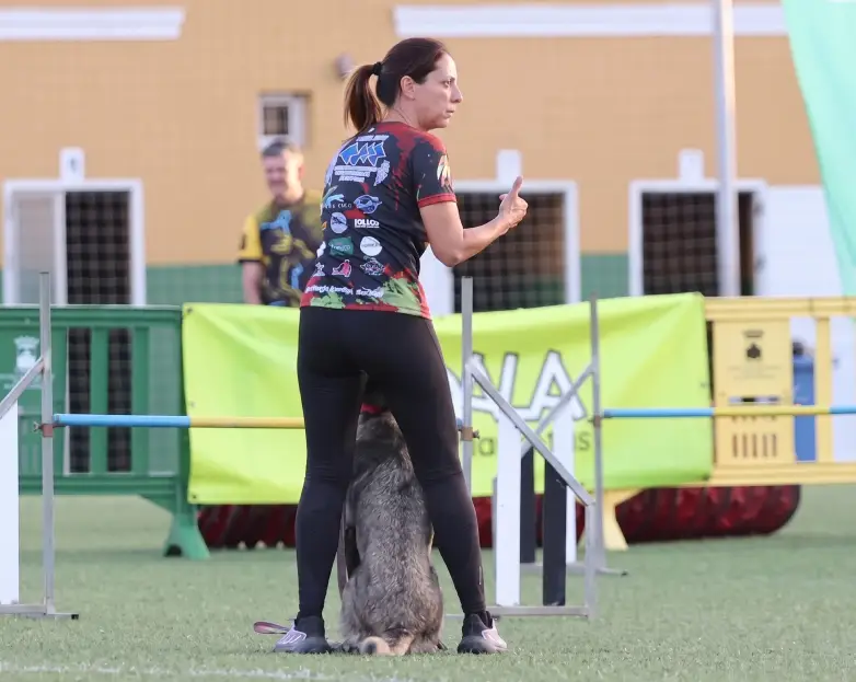 Woman training a dog at an agility course